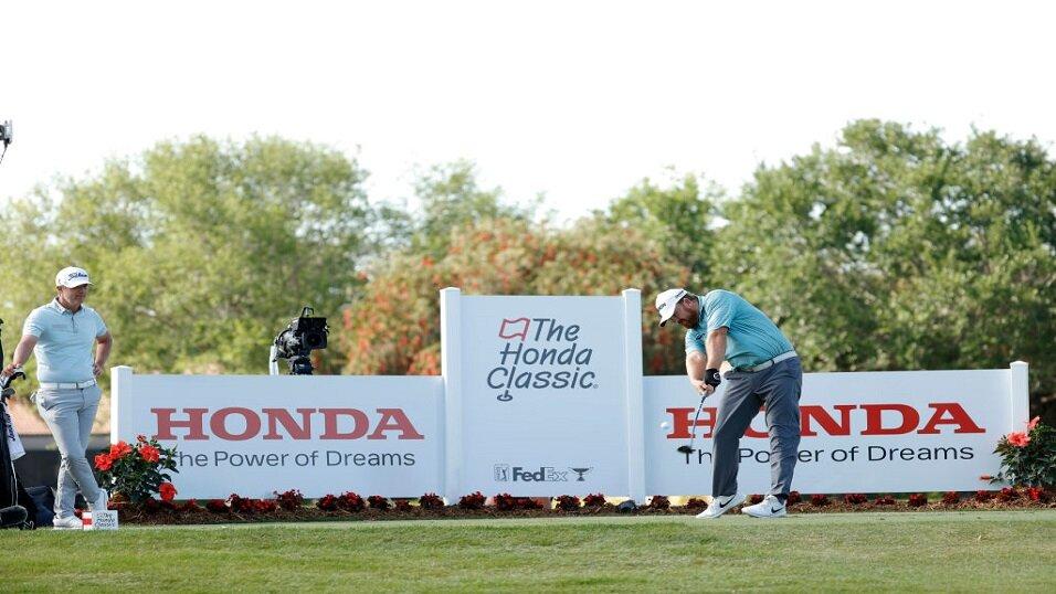Matt Jones looks on as JB Holmes tees off at the Honda Classic